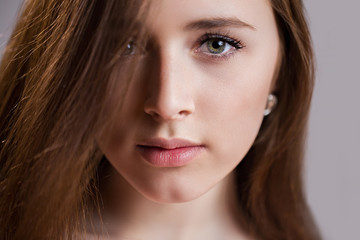 Fototapeta premium Horizontal closeup portrait of a beautiful young woman with clean skin, long eyelashes and natural beauty, fresh face