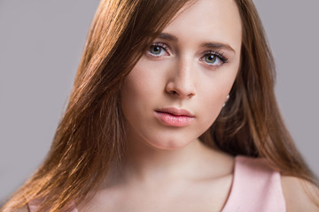 Naklejka premium Close-up portrait of cute young woman looking at camera