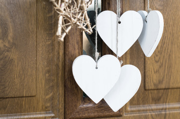 Wooden heart shape hanging under christmas wreath, copy space