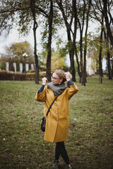 Naklejka premium Cute blonde is walking in autumn park
