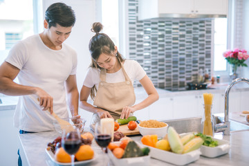 young asian couple cooking together in the kitchen at home.
