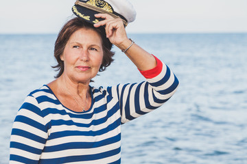 Pretty pleased elderly woman in sea suit on beach
