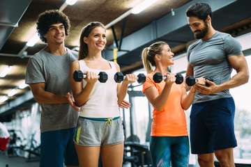 Young beautiful women doing exercises with personal trainers