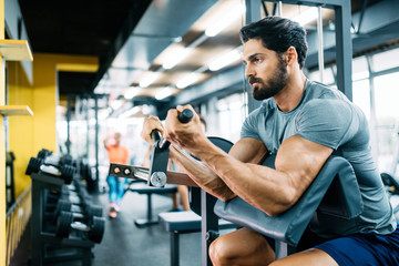 Fototapeta na wymiar Determined male working out in modern gym