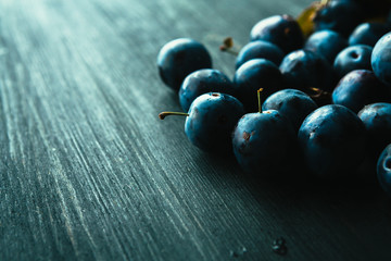 many fresh plums on black background close up