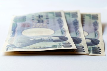 soft focus of Japanese yen note on the table with white shade background