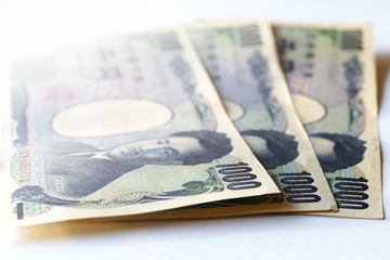 soft focus of Japanese yen note on the table with white shade background