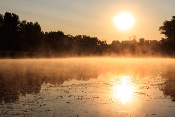 View of river in the mist at sunrise. Fog over river at morning
