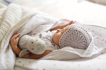 sweet sleep newborn in retro cap with handmade toy