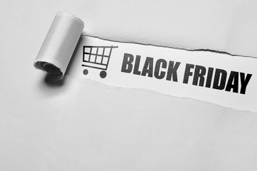 Black Friday message appering behind ripped paper