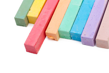 Colored chalks over a white background close up