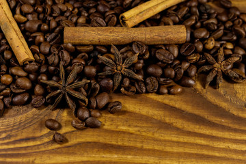 Coffee beans, cinnamon sticks and star anise on rustic wooden background