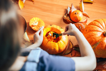 Young girl carving a pumpkin at Halloween