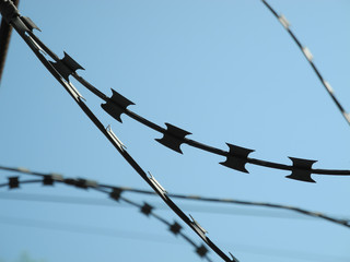 Barbed wire against blue sky