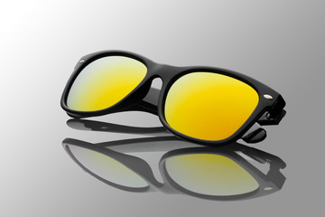 Studio shot of black sunglasses with yellow gradient mirrored. summer is coming concept. Polarizing...