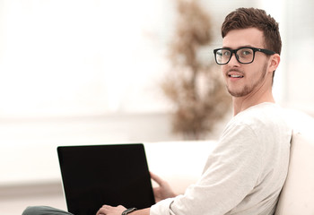 modern young man working on laptop sitting in the living room.
