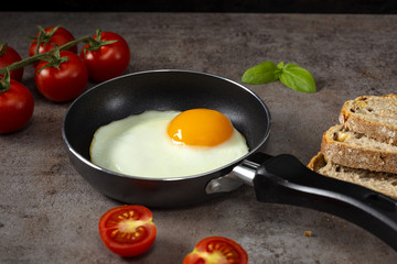 One egg in a little pan with cherry tomatoes