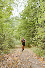 Obraz premium Jogging in the forest. Athlete running through the woods.