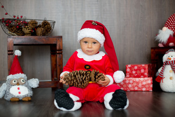 Cute toddler child, boy, playing with christmas decoration at home