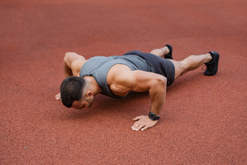 Athlete training in the open air. Workout on the playground.