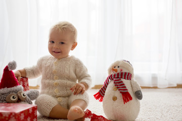 Cute toddler boy, sweet baby, opening presents at