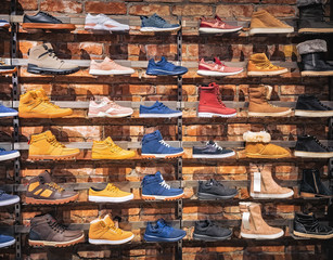 Shoes in the shop window. Lots of different men's and women's shoes sneakers, boots, plimsolls on...