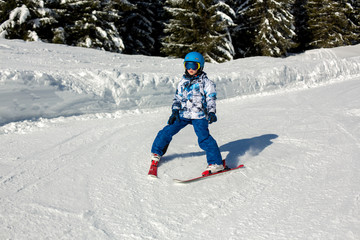 Fototapeta na wymiar Cute preschool child, boy, skiing happily in Austrian Apls