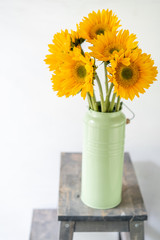 Bouquet of yellow sunflowers , flower in vase on old vintage table. Room morning. Gray background. Colors of autumn and mood fall
