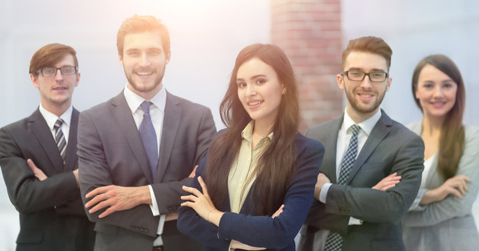 Attractive young business owner in office, folded hands  in fron