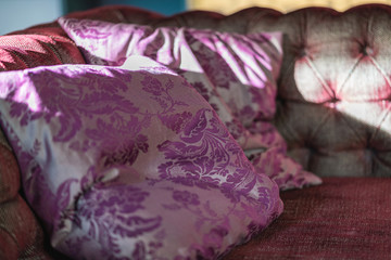 Picture of purple vintage looking pillows on the sofa in cafe