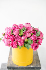 Beautiful spring bouquet in head box. Arrangement with mix flowers. The concept of a flower shop. Pink and yellow color. Work florist.
