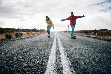 Couple of teenagers having fun skating and making downhill in Iceland