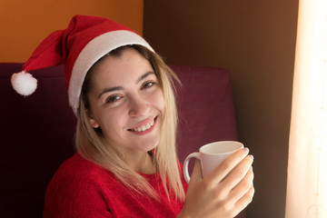 Happy girl drinking coffee at Christmas at home