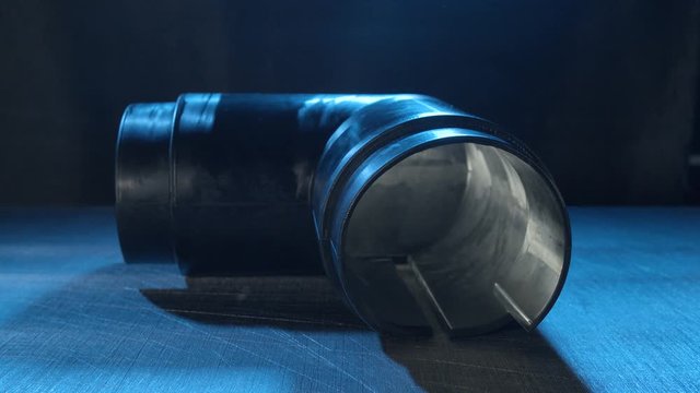 Industrial rubber tube on black background 4K. Zooming in on the rubber tube in focus with a black background.