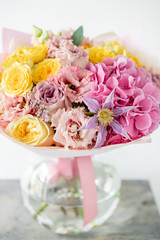 beautiful spring bouquet. flowers arrangement with various of colors in glass vase on old table. bright room, white wall. copy space
