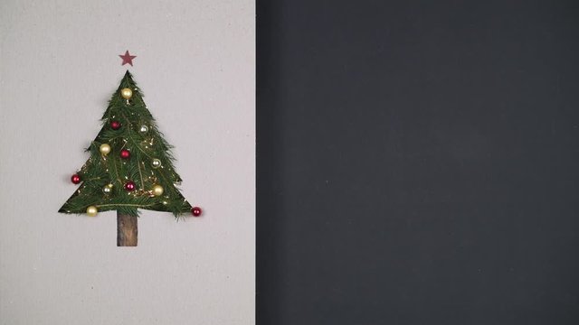 Overhead person hands preparing christmas tree pine decoration on cardboard.Blinking lights,text or logo copy space.Vertical top view,dark table.Xmas holiday season social card background.4k video