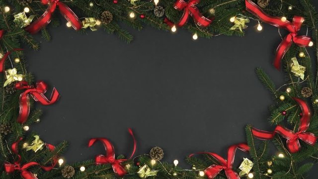 Looping overhead decoration frame on dark gray background with pine cones,branches,red gold ribbons,blinking lights.Text or logo copy space.Vertical top view.Xmas holiday season social card.4k video