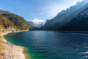 Obraz premium Gosausee bei Sonnenuntergang mit bunten Laubbäumen und Herbstblättern, an einem wunderschönen Herbsttag