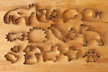 Different cookie forms on wooden background. Metal molds for cookies baking.