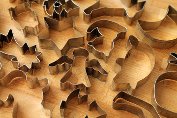 Different cookie forms on wooden background. Metal molds for cookies baking.