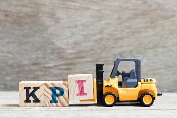 Toy forklift hold lette block I to complete word KPI (Abbreviation of Key performance indicator) on...