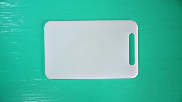 white cutting board lays on a table.