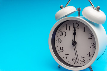 Clock on blue background with selective focus and crop fragment. Copy space concept