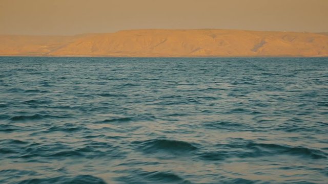 Ocean coastline on the sunset, ripples on the water.