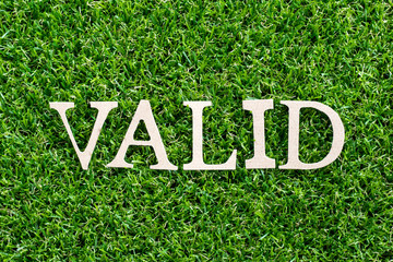 Wood letter in word valid on artificial green grass background