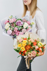 two beautiful spring bouquet. Young girl holding a flowers arrangements with various of colors. Bright dawn or sunset sun