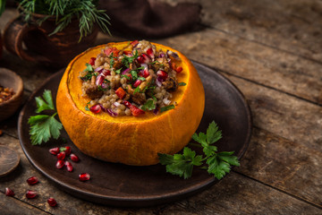 whole pumpkin stuffed with barley and vegetables, served with pomegranate and parsley