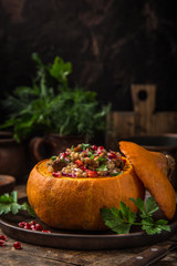 whole pumpkin stuffed with barley and vegetables, served with pomegranate and parsley