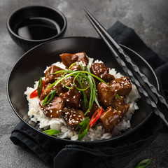 sweet sticky pork served with chives and  sesame seeds