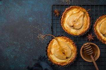 pear and custard tarts on dark blue background